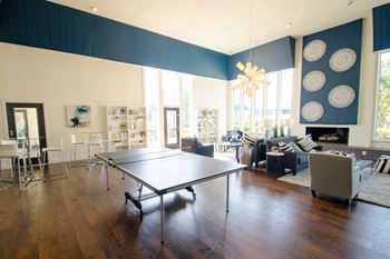A living room with a ping pong table in the middle.